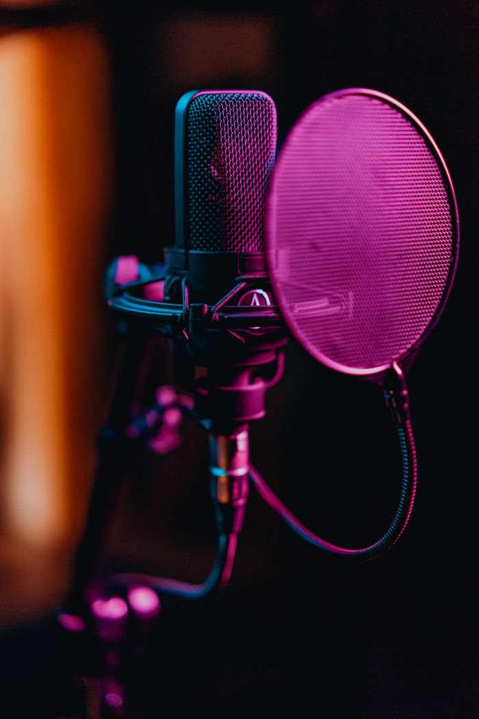 Mastering the First Impression: Your intriguing post title goes here Close-up of a professional condenser microphone and pop filter in a recording studio.